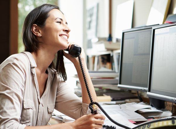 Smiling woman at desk on the phone to CTM support