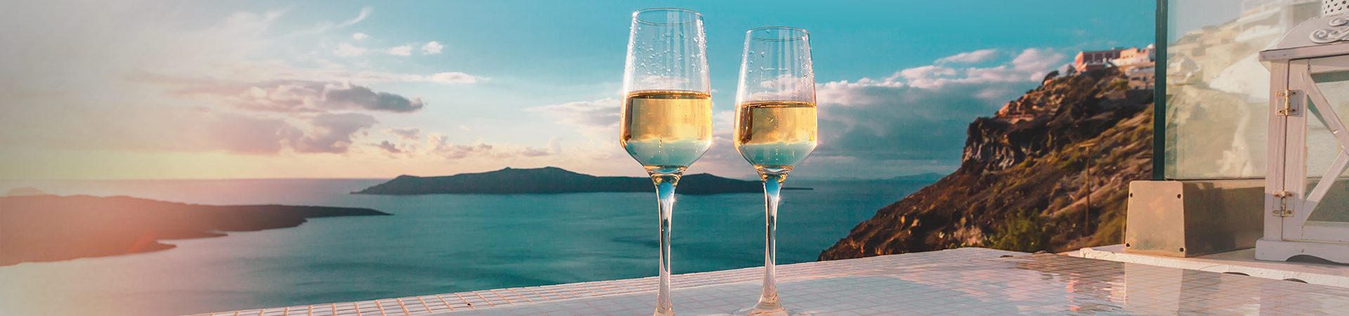 Two champagne glasses in front of sweeping ocean view